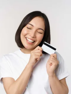 A woman happy using her Mission Lane Visa credit card.