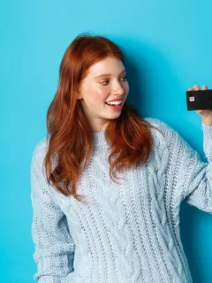 A girl holding her Prime Visa Amazon Credit Card.
