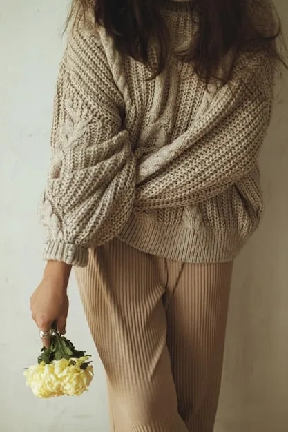 A close-up of a monochromatic outfit in warm beige tones, highlighting a ribbed knit sweater layered over a flowing silk skirt. A detailed shot of a matching suede pump and a quilted leather bag in similar hues.