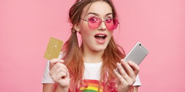 Young woman holding her Discover it Student Cash Back.