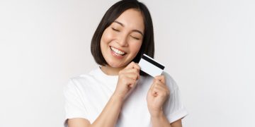 A woman happy using her Mission Lane Visa credit card.