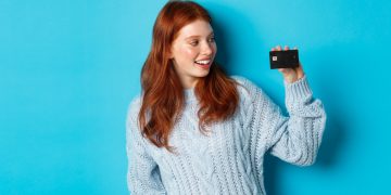 A girl holding her Prime Visa Amazon Credit Card.