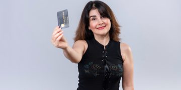 A woman holding her QuicksilverOne Capital One.