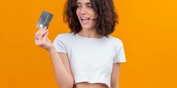 A girl holding her Wells Fargo Active Cash credit card.