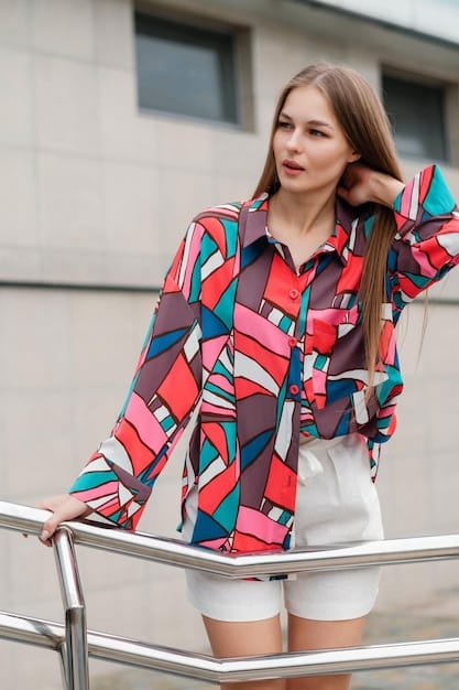 A detailed shot of an outfit where a geometric print blouse is layered under a richly textured, solid-colored knit cardigan, showcasing how texture adds depth to print mixing. The cardigan has prominent ribbing, creating strong visual interest.