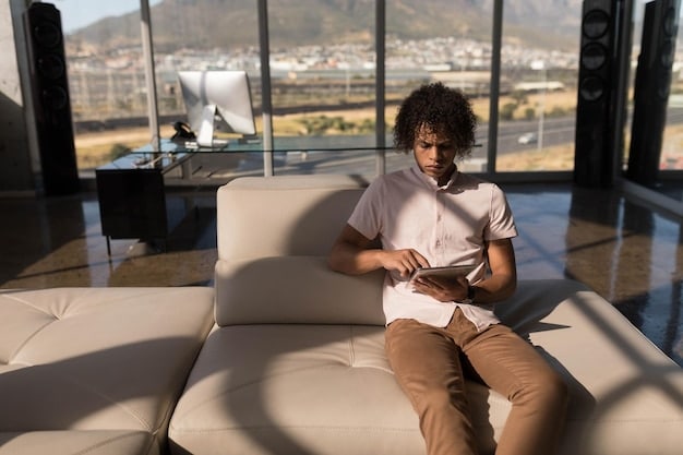 A person using a laptop comfortably in a well-lit, modern airport lounge, surrounded by minimalist decor and other relaxed travelers.